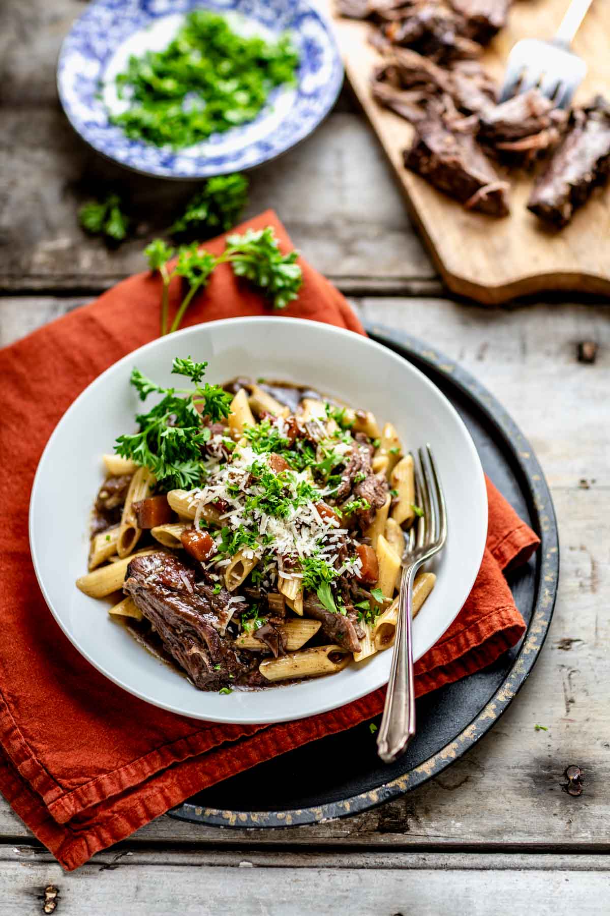 side view of the beef and pasta dish on an orange napkin