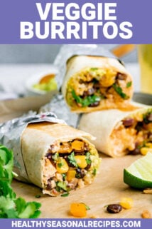 veggie burritos on a piece of parchment paper with beans, peppers, rice, and corn inside