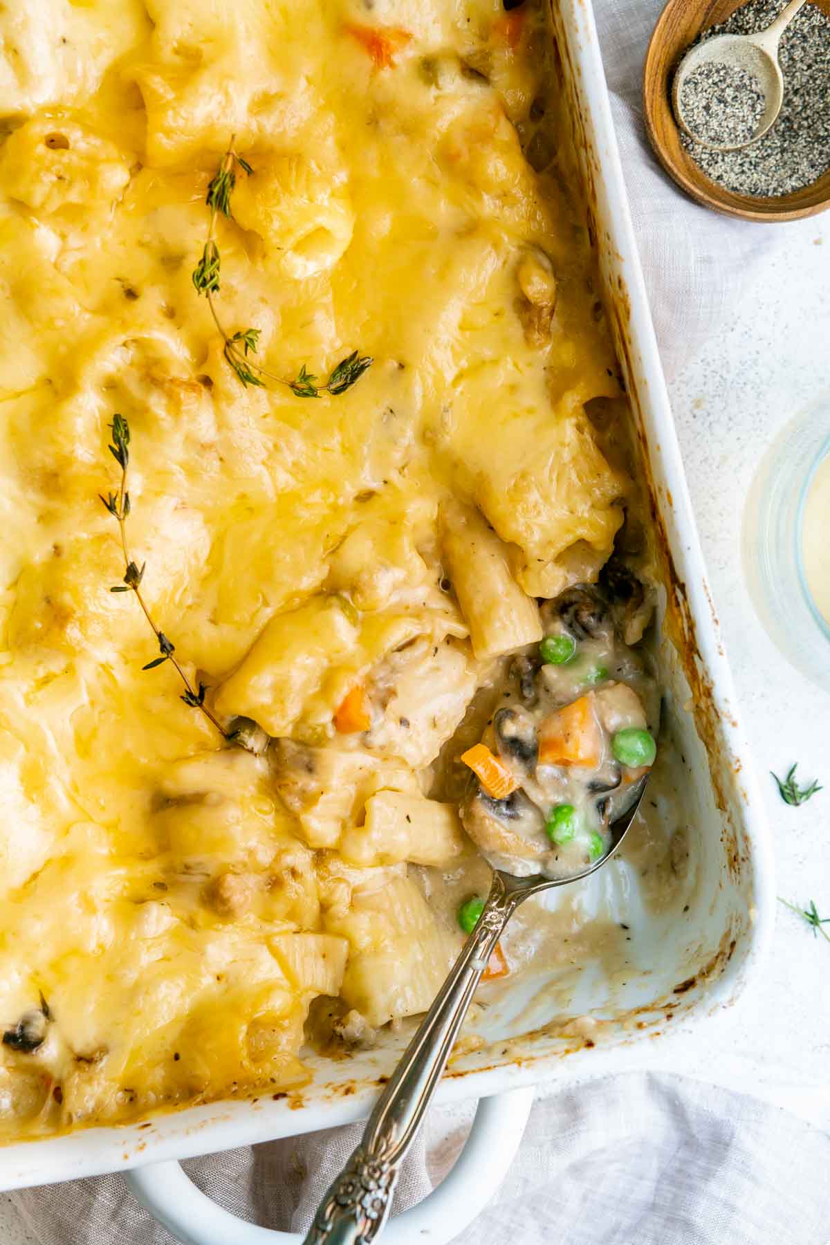 overhead shot of creamy pasta bake with portion removed and ingredients on spoon