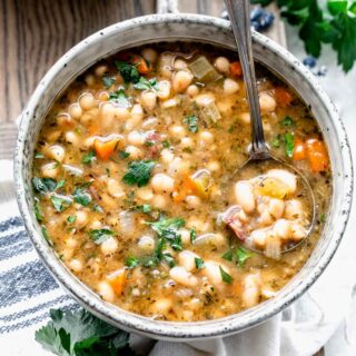 spoon full of ham and white bean soup in bowl of soup