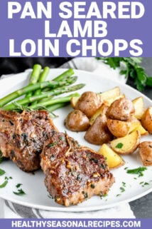 two lamb chops on a plate with asparagus and potatoes