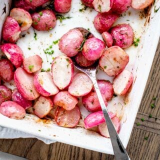 roasted radishes in white dish with two on a spoon