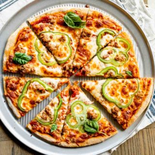 Baked whole wheat pizza dough, cut into triangular pieces on a pizza pan.