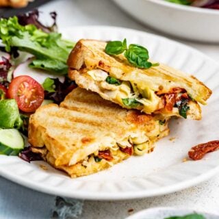 the panini on a plate with a garden salad on the side