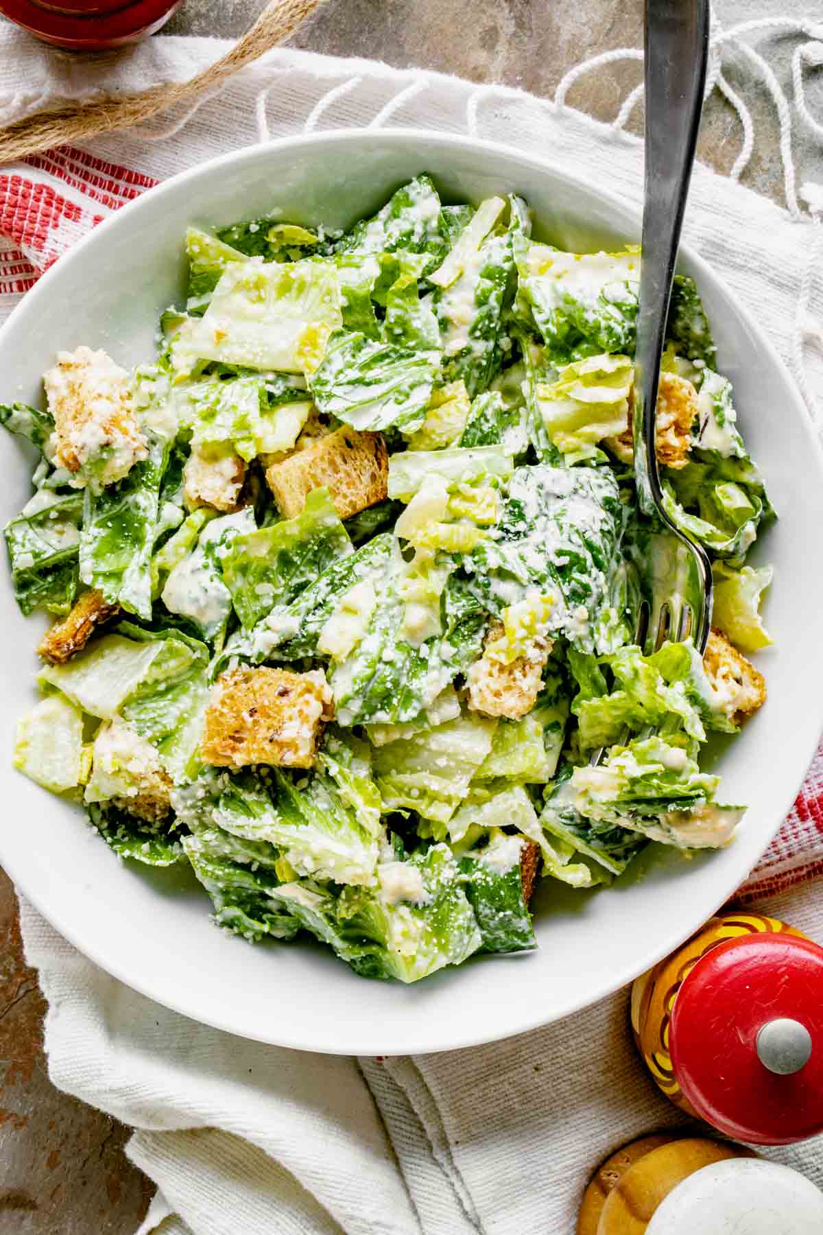Caesar salad in a white bowl with a fork