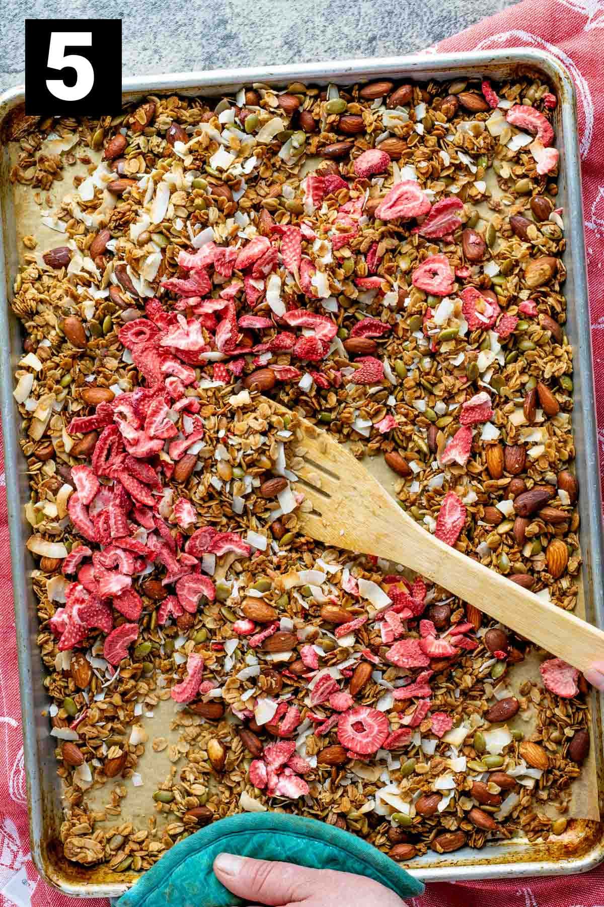 add the freeze dried strawberries to the sheet pan mixture and stir so everything is evenly combined
