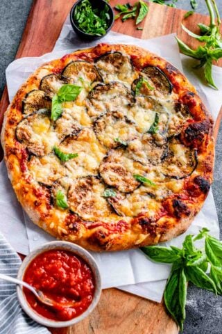 overhead photo of eggplant pizza on wooden cutting board