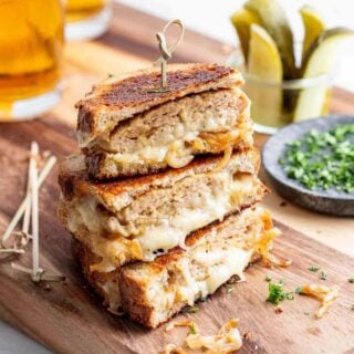 three halves of ground turkey sandwiches on top of each other being held with a tooth pick