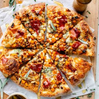 butternut squash pizza cut into 8 triangles on a cutting board