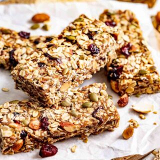 healthy homemade granola bars stacked on top of each other on parchment paper