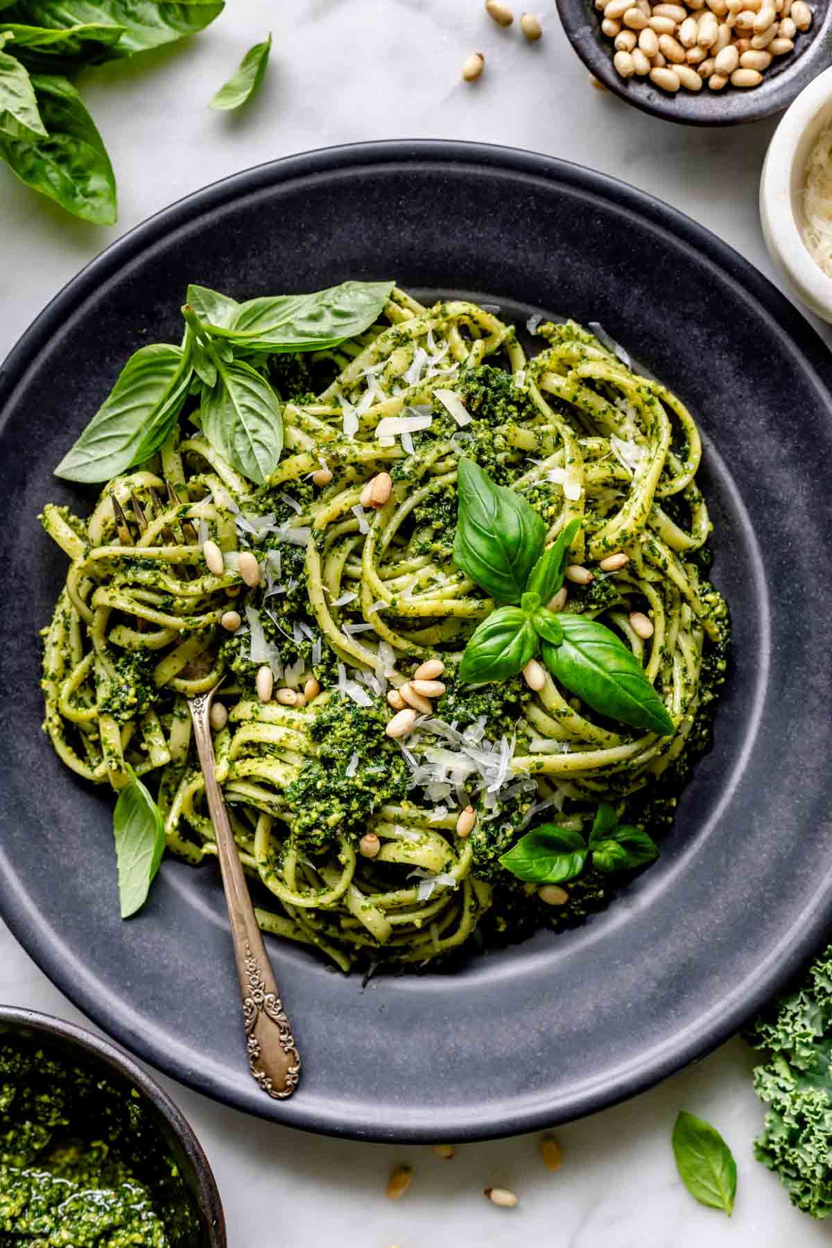 Pasta in a black bowl dressed in homemade kale pesto