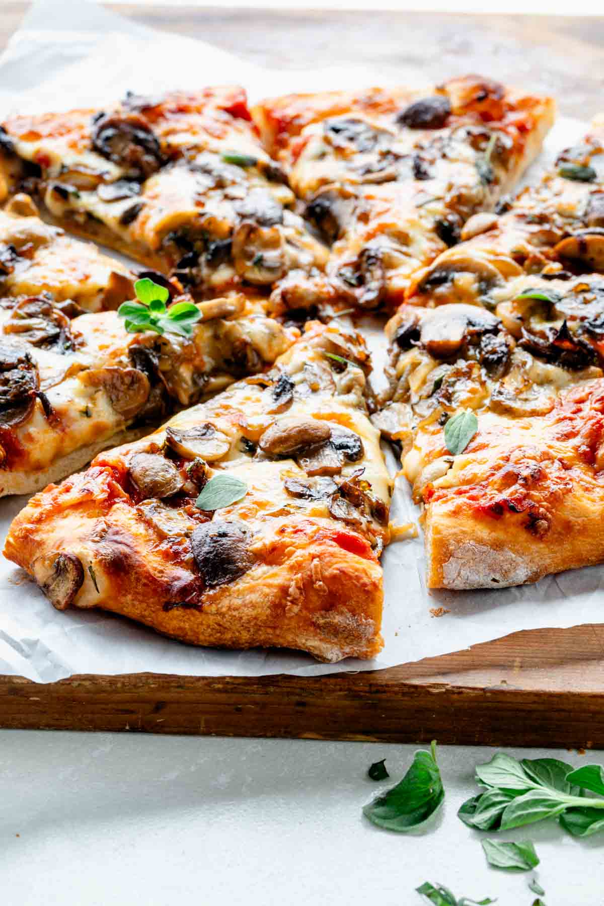 side view of sliced mushroom pizza on cutting board