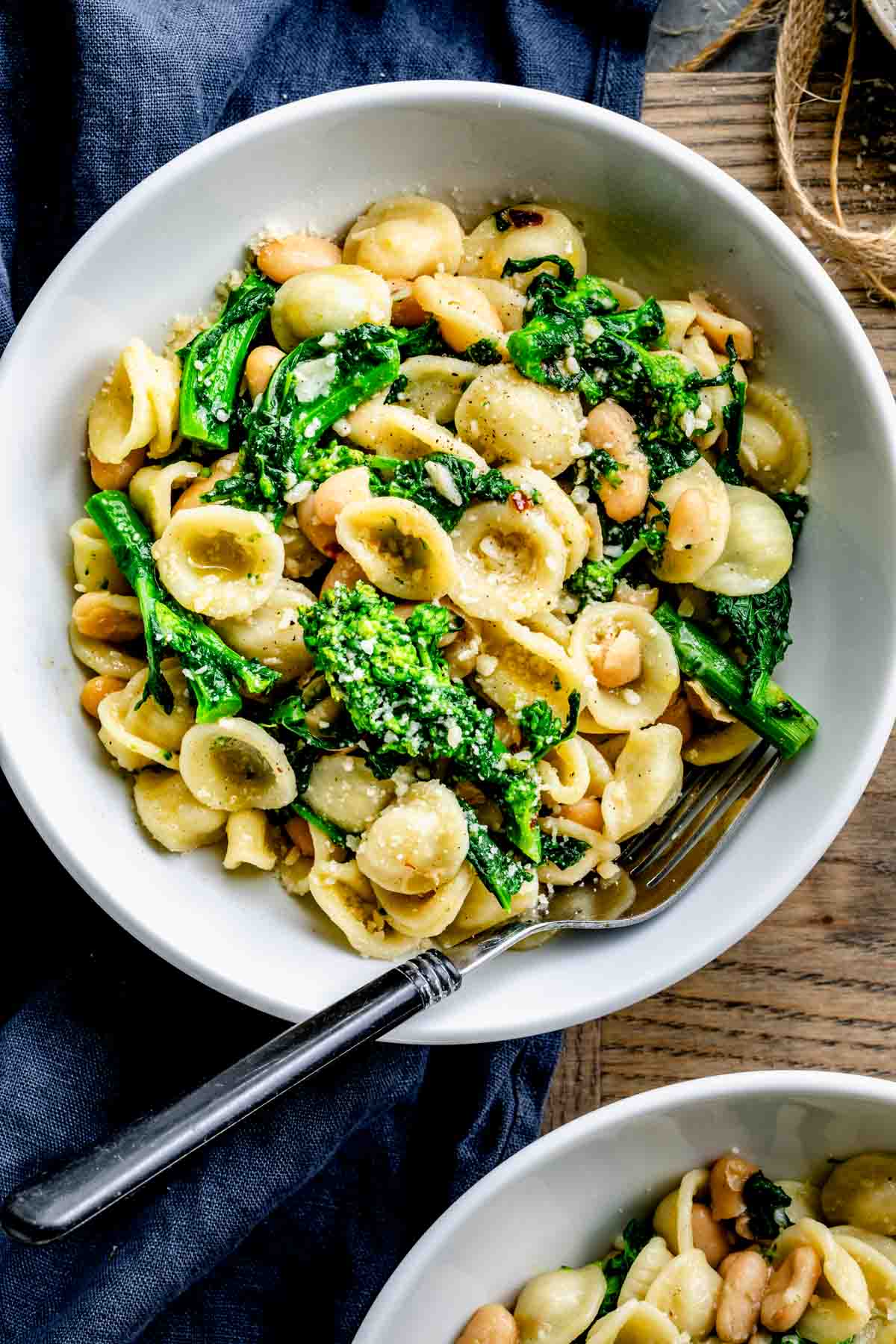 broccoli rabe with pasta in circular white bowl with a spoon