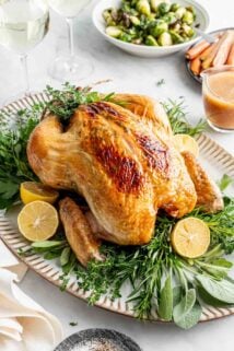 the whole roasted chicken on a platter garnished with herbs