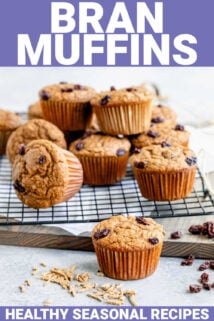 a batch of bran muffins on a cooling rack from the side in a white kitchen with oats on the counter