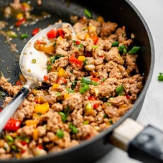 ground turkey, peppers, with a hoisin stir fry in a fry pan with a spoon