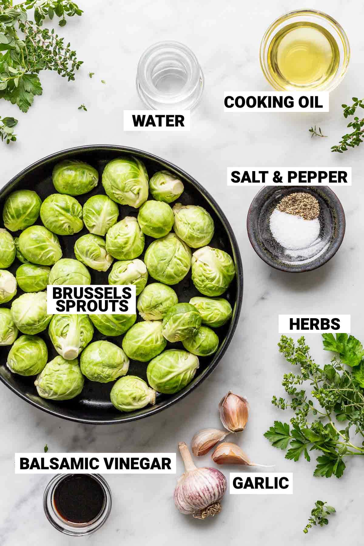 brussels sprouts, balsamic vinegar, garlic, herbs, salt, pepper, cooking oil, and water all on a white surface to make simple sauteed brussels sprouts in a cast iron skillet