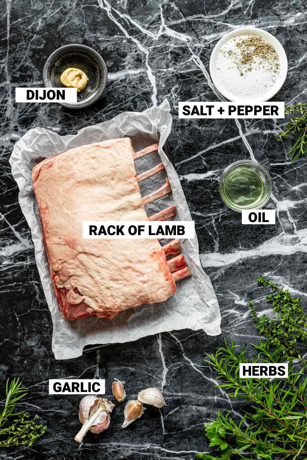 the ingredients for the garlic herb lamb on a black marble table top with labels for each ingredient