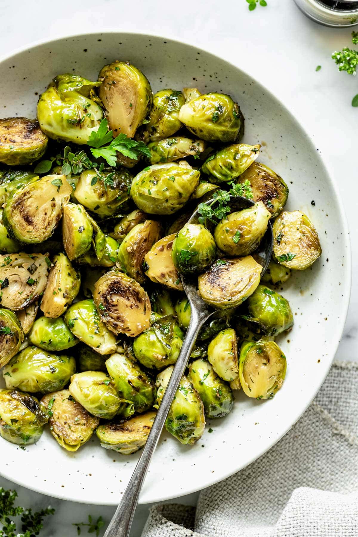 the sauteed brussels in a white serving dish