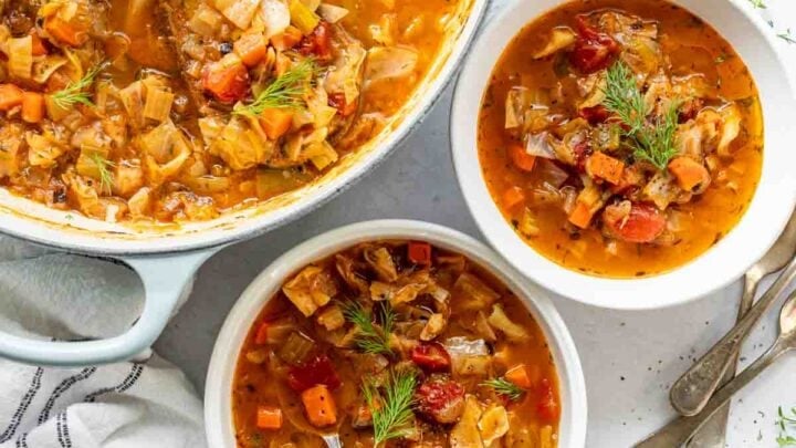 Cabbage soup in a pot with two bowls