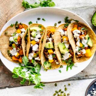 overhead photo of winter squash tacos on circular white plate