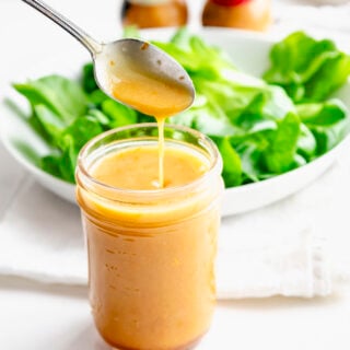 close up of orange miso vinaigrette in mason jar