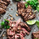 the steak on a baking sheet with cilantro, lime and chopped peanuts