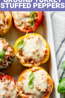 text overlay on photo of the stuffed peppers from overhead with melted cheese on top and basil garnish