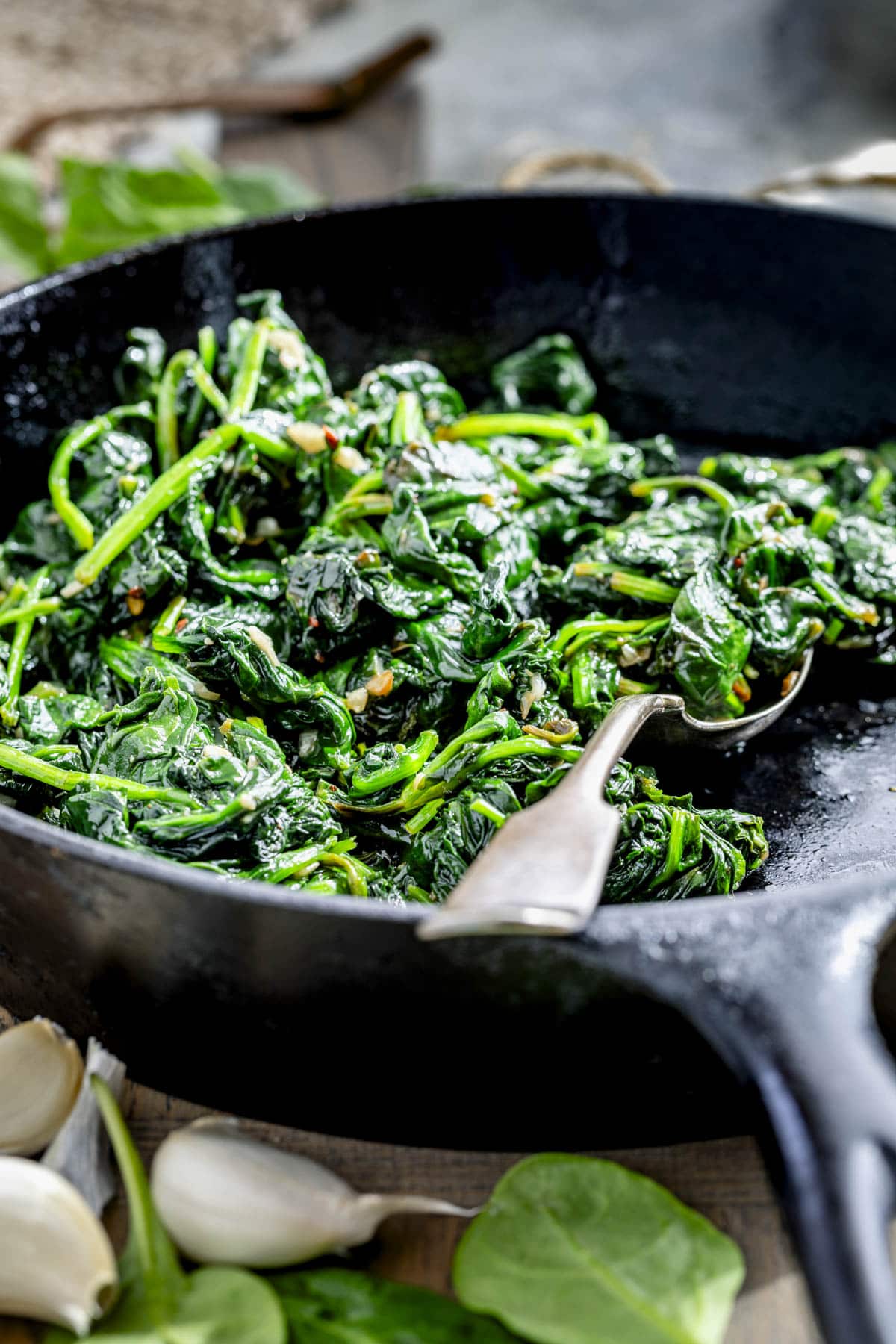 the cooked spinach in a black cast iron skillet from a side angle