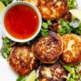 amazingly golden brown fried fish cakes on a platter with herbal salad and dipping sauce