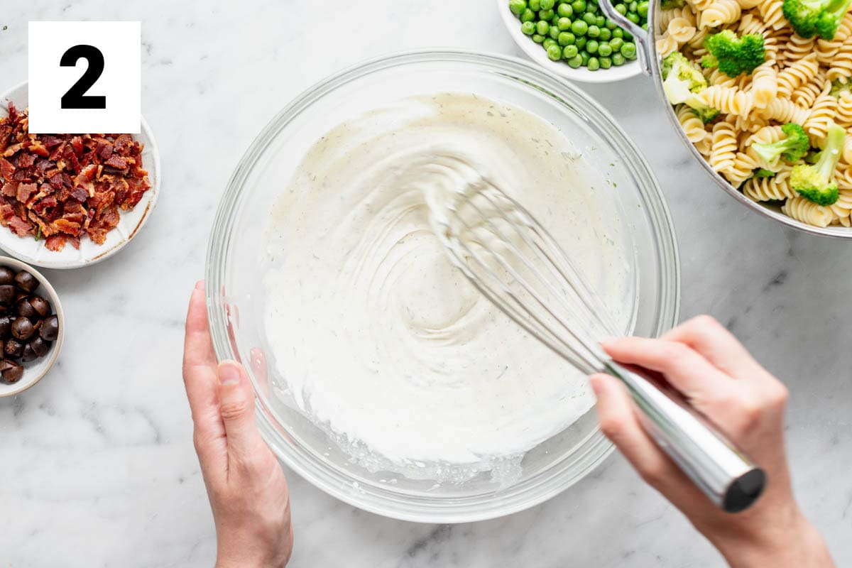 whisking the dressing in a glass bowl