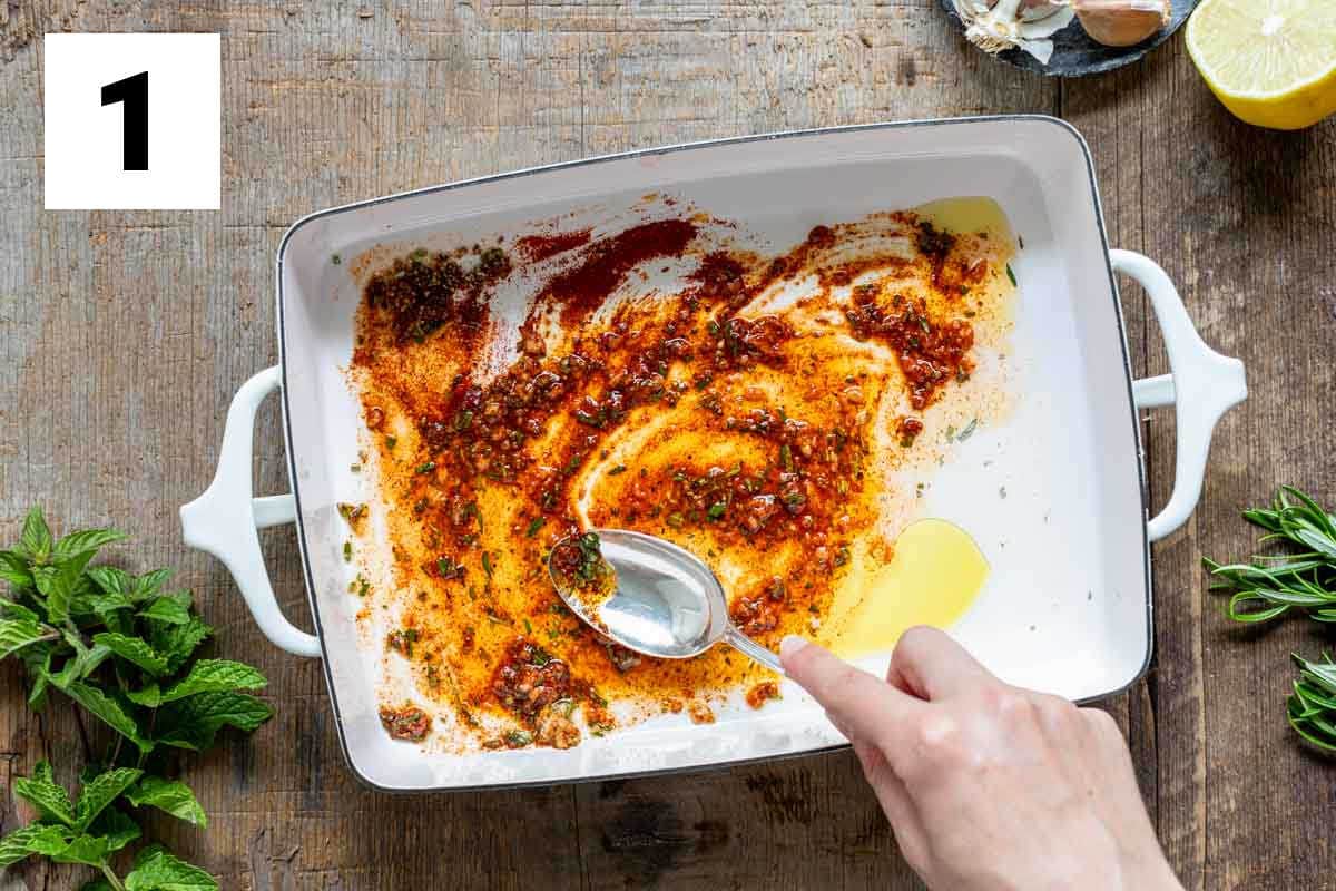 a spoon spreading lamb marinade in a shallow white bowl