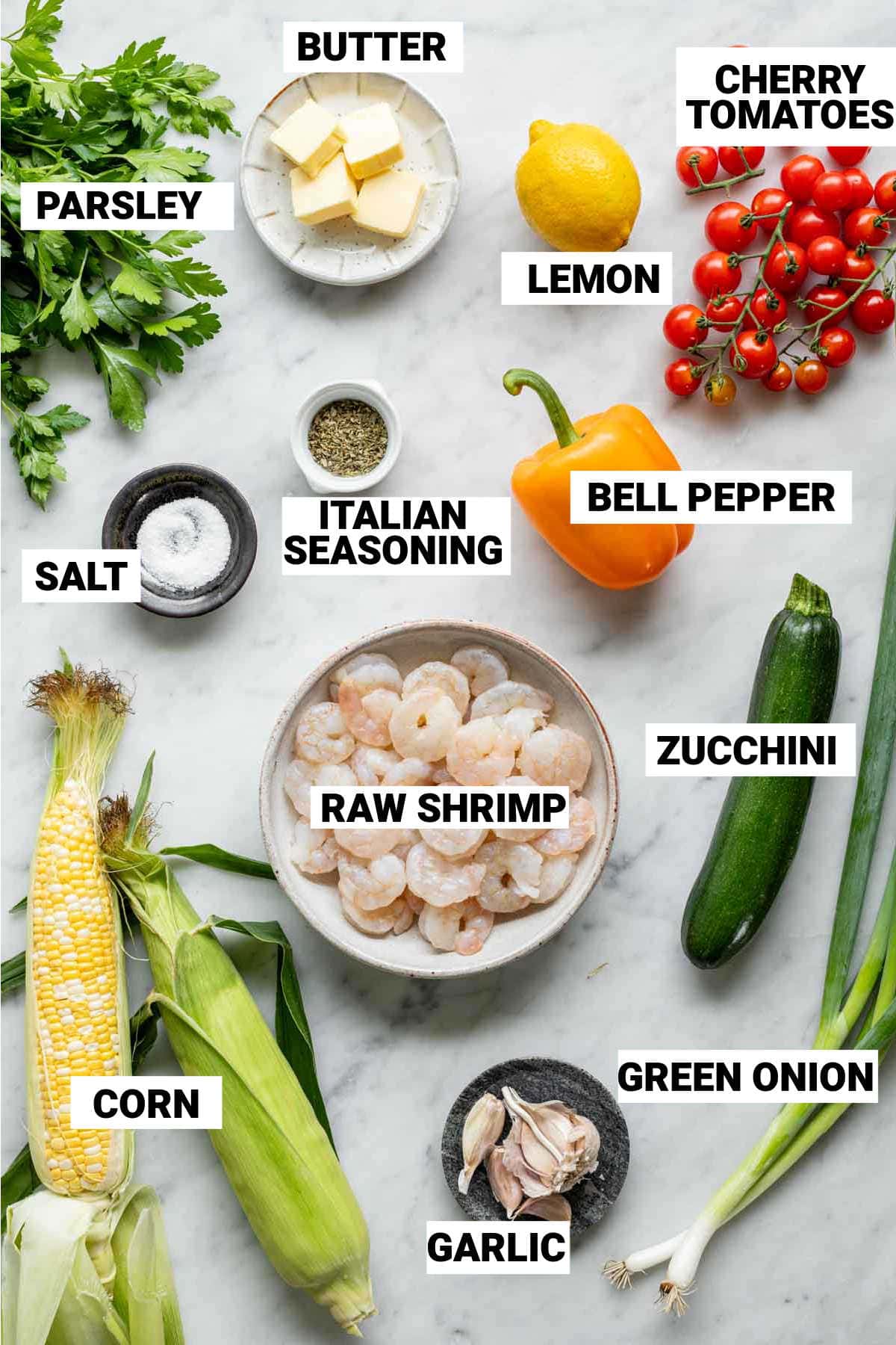 bell pepper, cherry tomatoes, lemon, raw shrimp, zucchini, salt, italian seasoning, corn on the cob, garlic, green onion, parsley, and butter