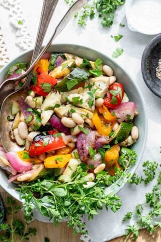 grilled vegetable salad with white beans in circular white bowl