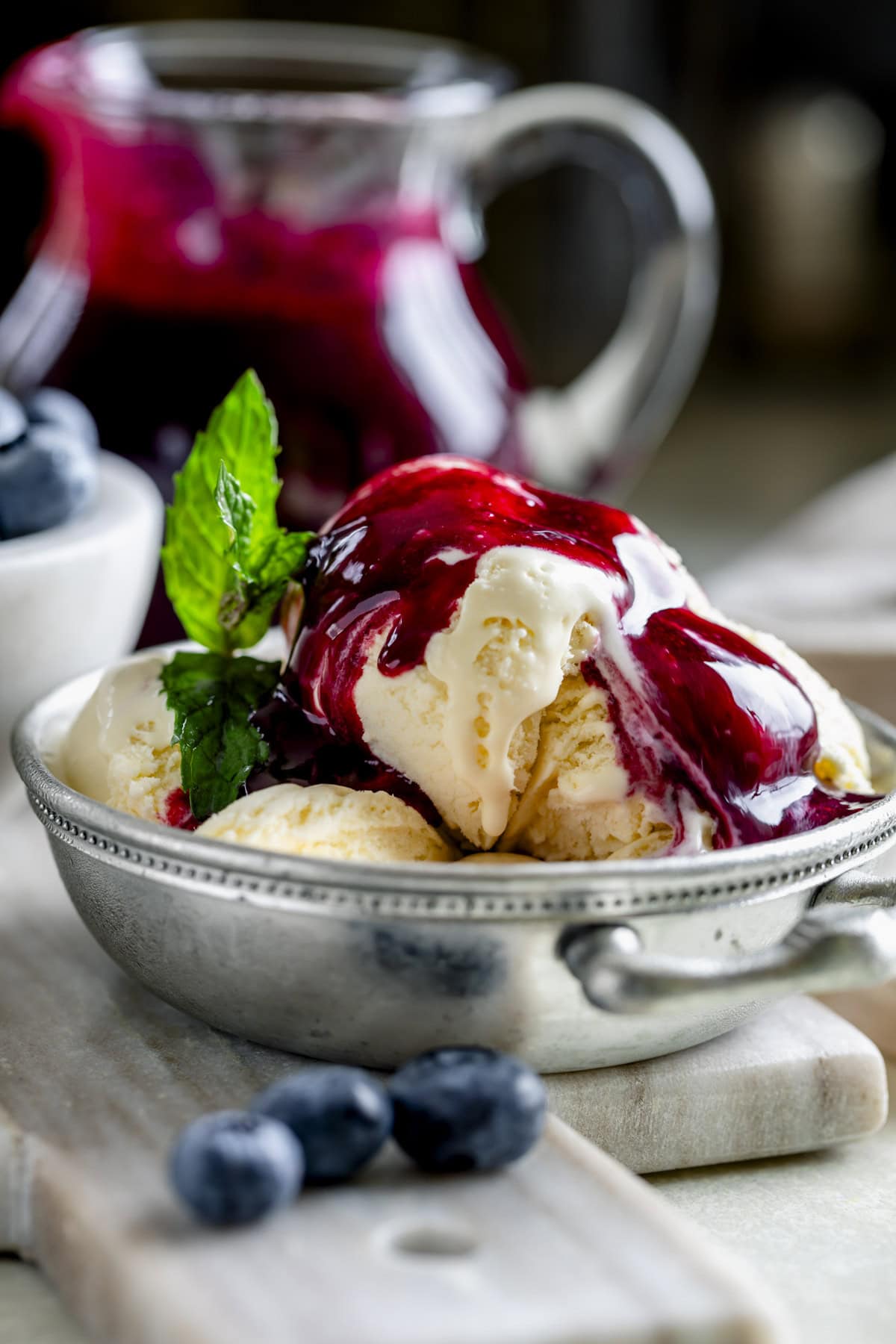 homemade blueberry sauce drizzled over vanilla ice cream