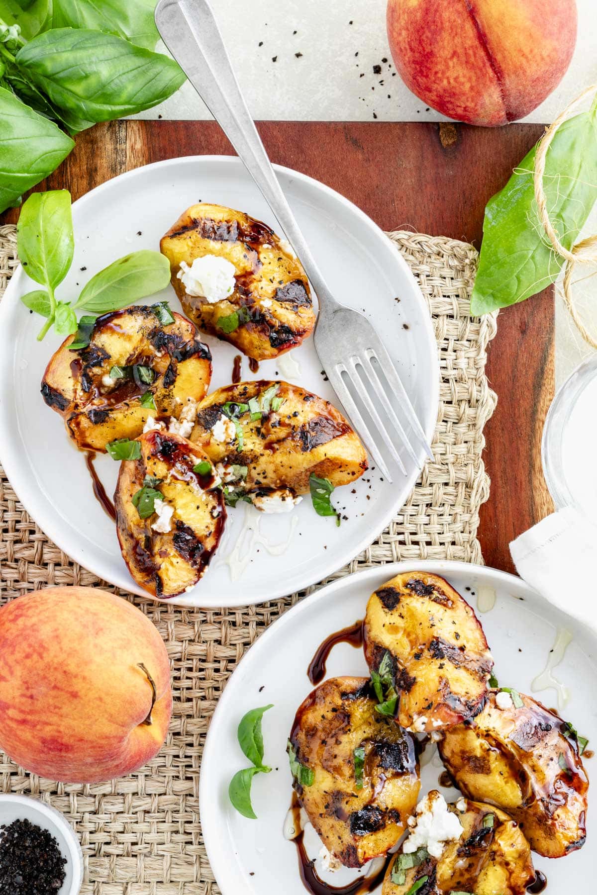 the grilled peaches on two plates