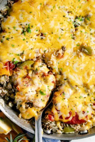 unstuffed peppers skillet with melted yellow cheese on top close up with a scoopful about be be removed