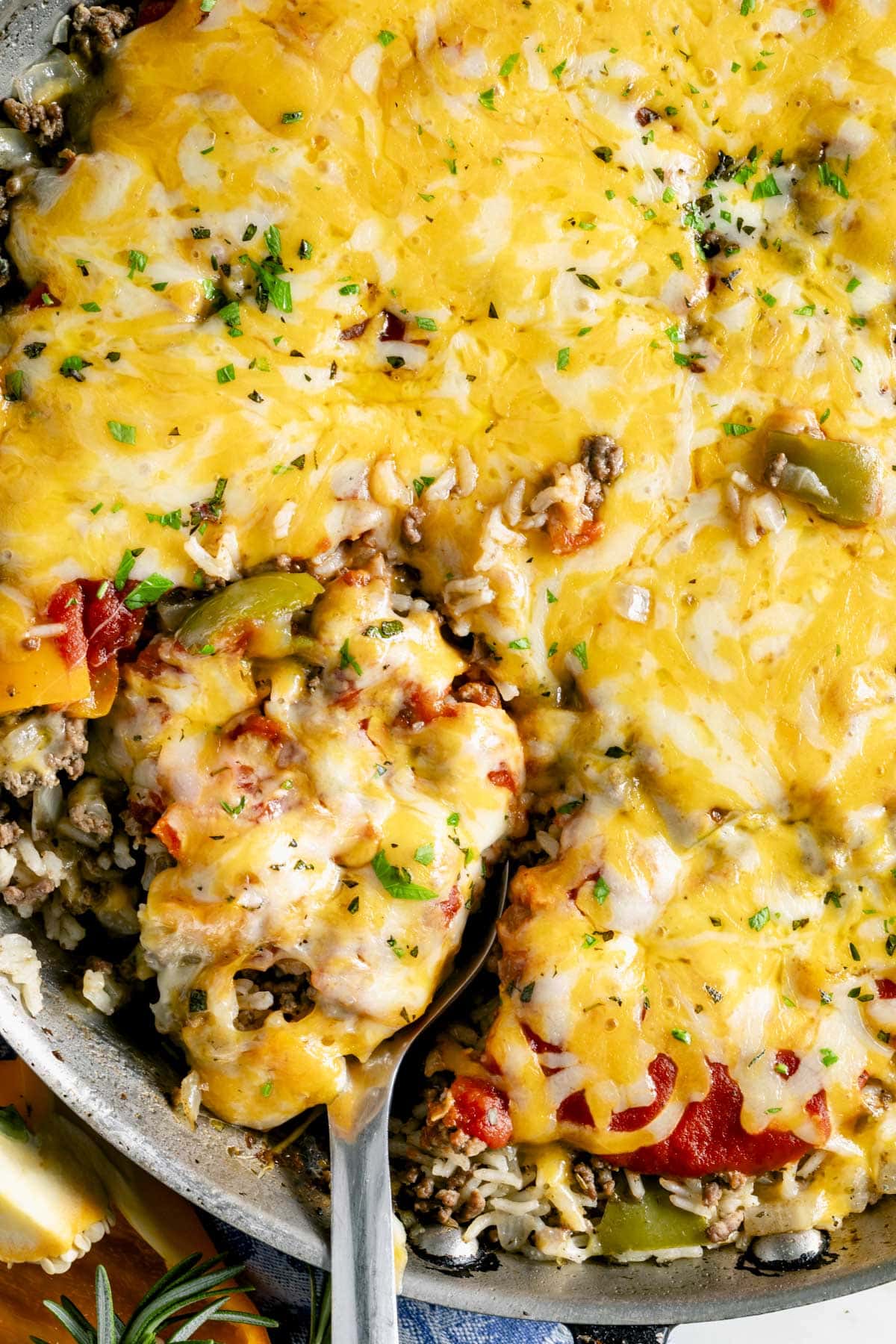 unstuffed peppers skillet with melted yellow cheese on top close up with a scoopful about be be removed