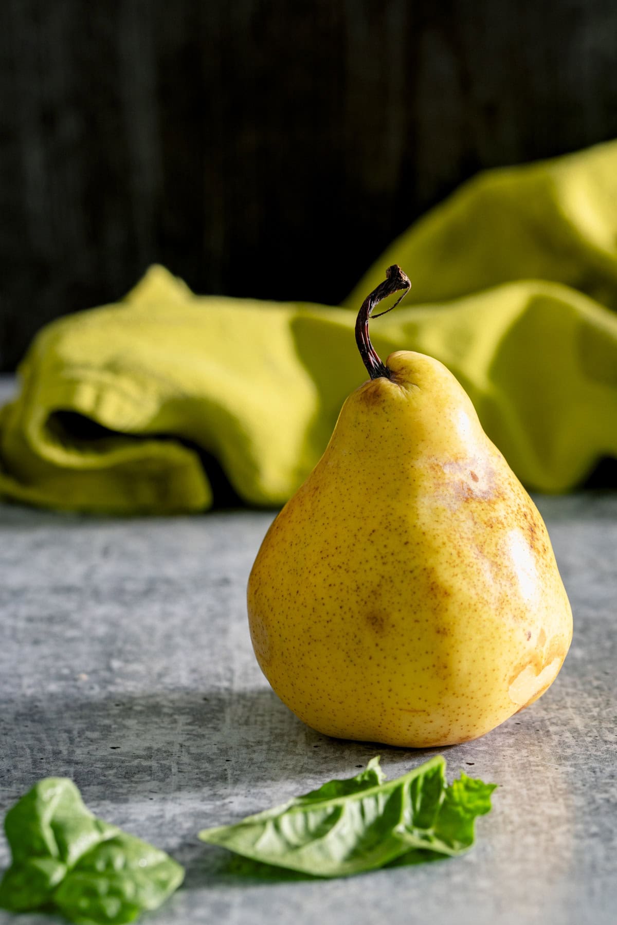 a bartlett pear with a few spinach leaves