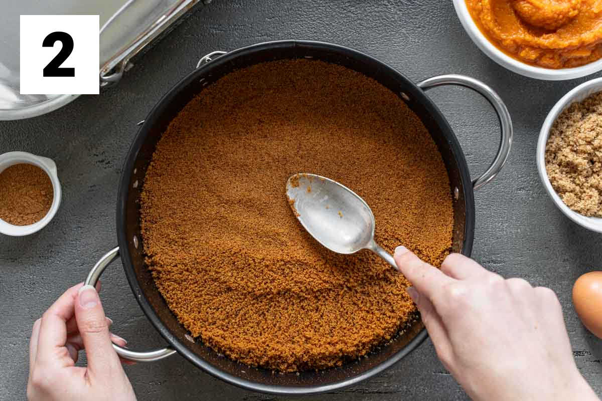 pressing the cookie crumb mixture into the pan to form the crust