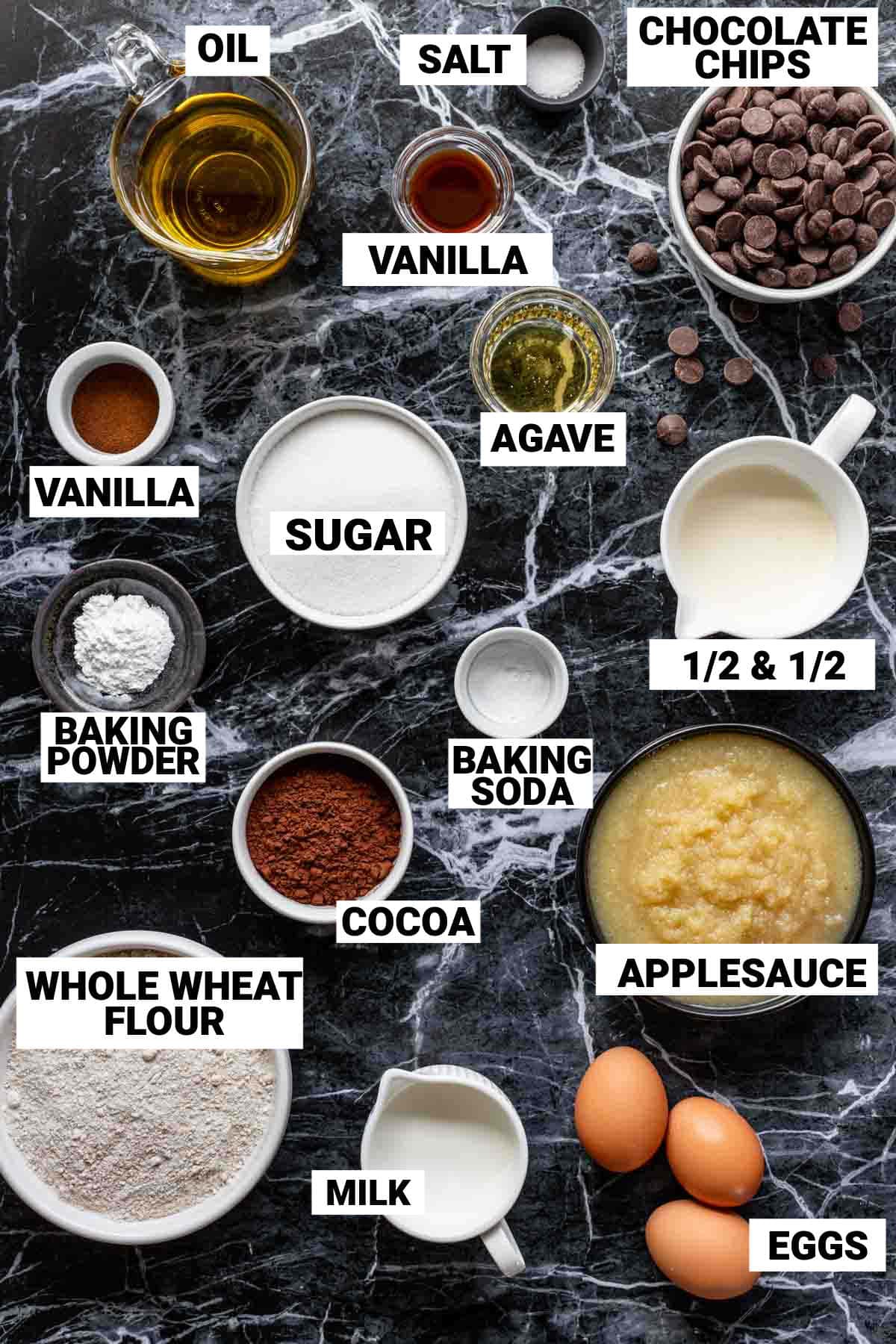 the chocolate cake ingredients on a black marble countertop with text overlay labeling each item