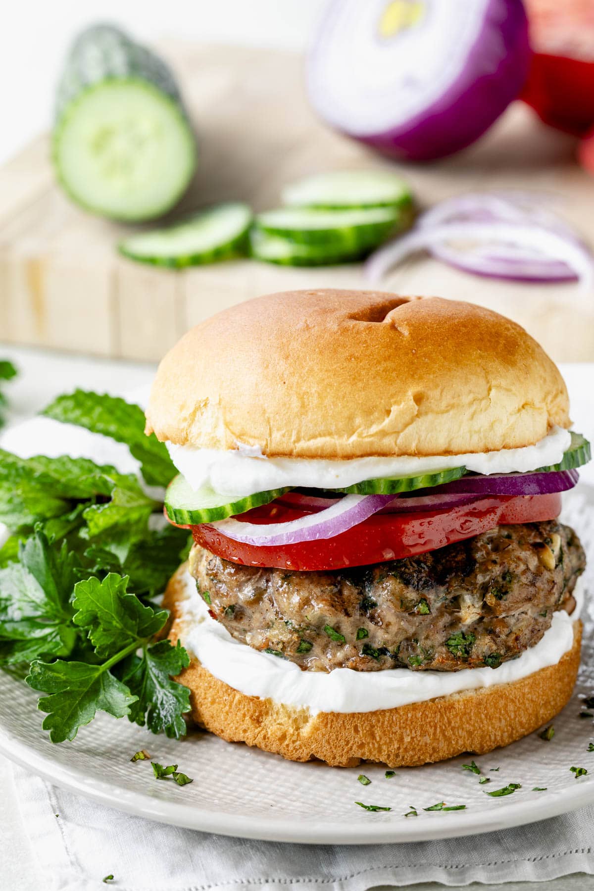 a grilled turkey burger on a toasted bun with garnish to the left side