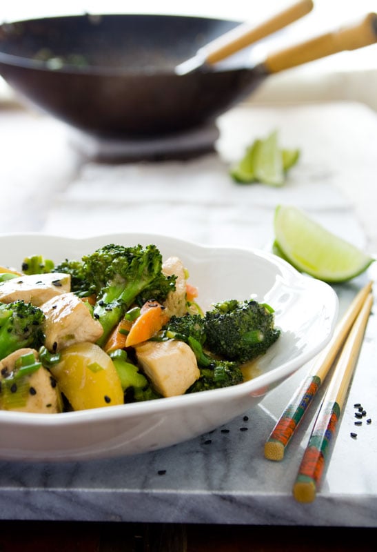 Broccoli Chicken stirfry in a white bowl with chopsticks